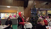 Sallin puuropuhe lapsuuden joulusta sai yleisön mietteliääksi...
Kuvassa mukana kirkkoherra Eija Nivala sekä taustalla keittiössä ahertavat 'tontut'.